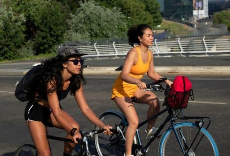 normas de trânsito para ciclistas: Imagem de duas mulheres andando de bicliceta.