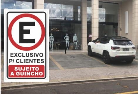 Imagem mostrando um estacionamento em recuo de calçada com a placa de estacionamento exclusivo para clientes, sujeito a guincho