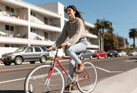 normas de trânsito para ciclistas: Imagem de jovem mulher andando de bicicleta.